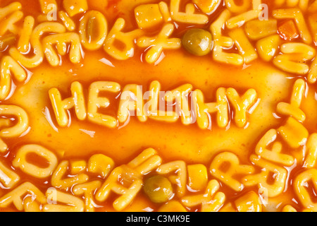 Alphabet geformten Nudeln bilden das Wort gesund in Tomatensauce Stockfoto
