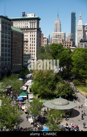 Blick nach Norden am Union Square Park an einem Tag Greenmarket. Das Empire State Building dominiert die Skyline in der Ferne. Stockfoto