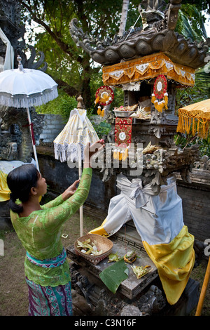 Indonesien, Insel Bali, in der Nähe von Tejakula Dorf, Gaia Oasis Resort. Frau verehren im Haus Tempel. Stockfoto