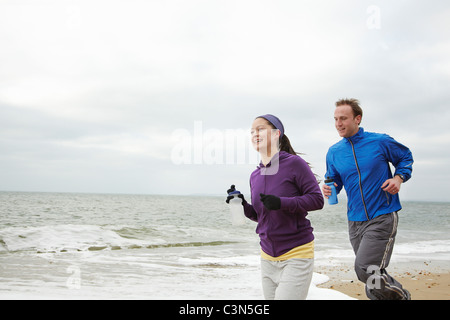 Paar am Strand an bewölkten Tag ausgeführt Stockfoto