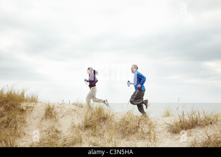 Paar Ausübung auf Sanddünen am Strand Stockfoto