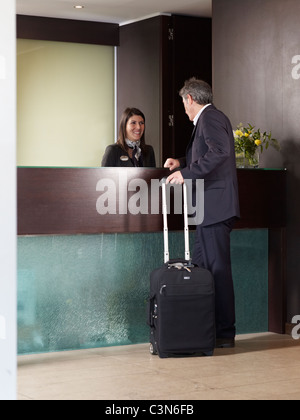 Senior woman Einchecken an der Rezeption eines Hotels Stockfoto