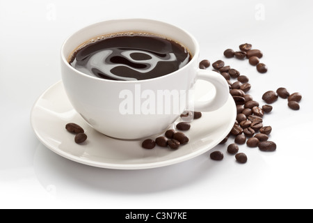 Tasse Kaffee mit Kaffeebohnen auf weißem Hintergrund. Stockfoto