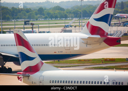 Zwei British Airways Flugzeuge passieren auf dem Rollfeld am Flughafen Gatwick. Stockfoto