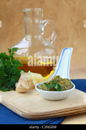 Basilikum-Pesto in einem keramischen Löffel Stockfoto