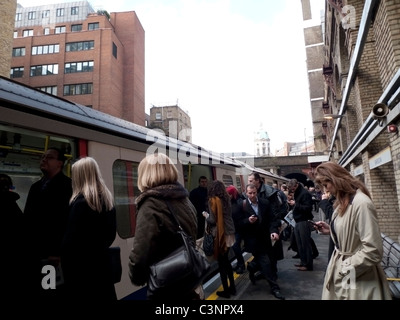 Am frühen Morgen Pendler auf Handys Auf- und Absteigen von der U-Bahn im Barbican Station in London England Großbritannien UK KATHY DEWITT Stockfoto