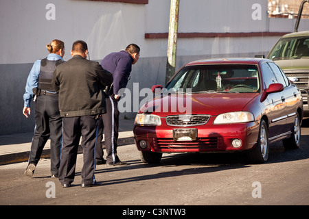 Juarez Polizei schauen Sie in ein Auto wo der Fahrer tot Momente früher in der Droge Kriege Juarez, Mexiko erschossen wurde Stockfoto