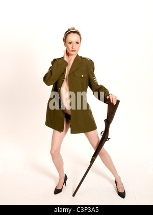 Hübsches Modell nur tragen Army Jacke und high Heels mit Gewehr. Stockfoto