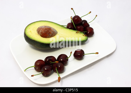 Avocado und frischen Kirschen auf den weißen Teller Stockfoto