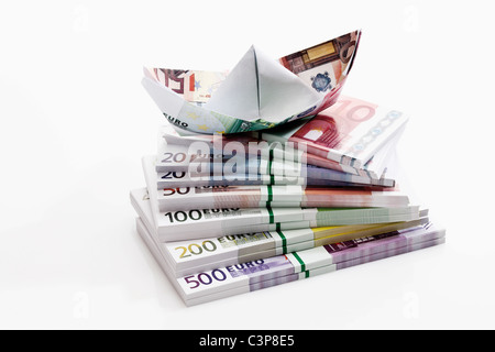 Euro Papierschiff auf Bündel von Euro-Banknoten, Nahaufnahme Stockfoto