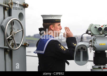 Königliche Marine Seemann Rohre einen Gruß. Stockfoto