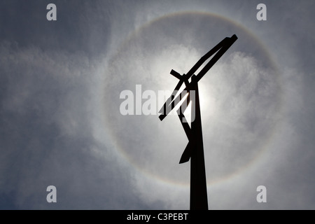 Die Sonne, umgeben von einem Heiligenschein sieht man oben eine Skulptur, die Jesus Christus am Kreuz von Fatima, Portugal. Stockfoto