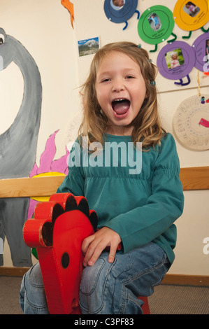 Deutschland, Mädchen (4-5) sitzen auf Schaukelpferd, Porträt Stockfoto