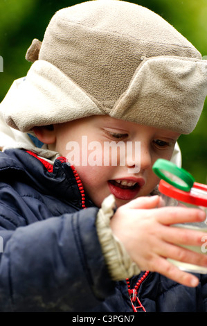 Ein kleiner Junge eine Naturbeobachtung und Dippen Sitzung bei der RSPB Conwy Reserve Teich genießen. Stockfoto