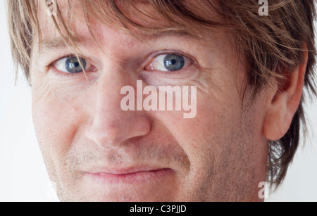 Nahaufnahme von mittlerem Alter Mann lächelnd und Blick direkt auf die Kamera Stockfoto