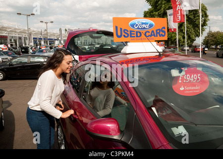 Autohändler teen; Ein 17-jähriges Mädchen im Teenageralter, das ihr erstes Auto kaufte, Marshalls Gebrauchtwagenhändler Lot, Cambridge, Großbritannien Stockfoto