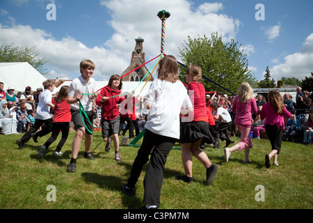 Kinder aus einer örtlichen Grundschule Tanz runden den Maibaum am Maifeiertag zu erreichen Fair, Reach, Cambridgeshire, Großbritannien Stockfoto