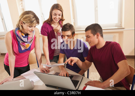 Deutschland, Emmering, Studenten diskutieren und mit laptop Stockfoto