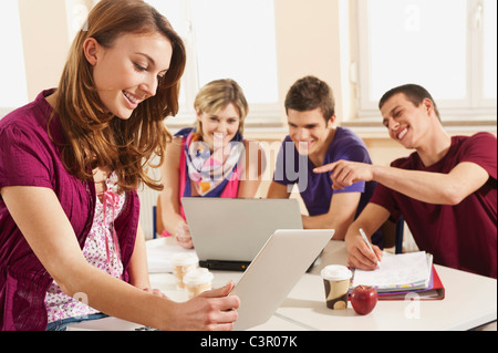 Deutschland, Emmering, Teenage Mädchen mit Laptop mit Studenten im Hintergrund Stockfoto