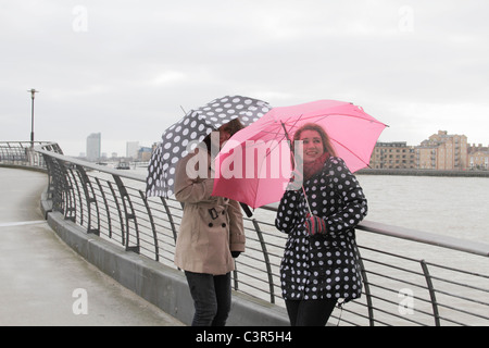 2 Yougn Frauen mit Sonnenschirmen Fluss Stockfoto