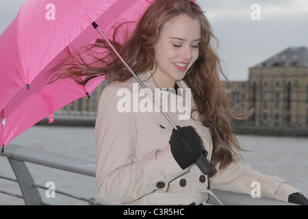 Junge Frau mit rosa Regenschirm Stockfoto