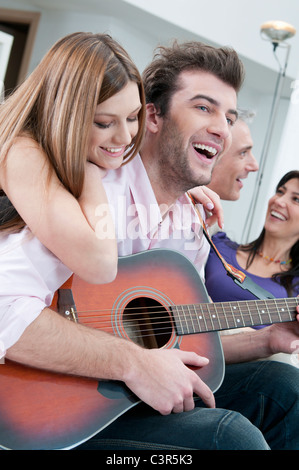 Freunde, Gitarre zu spielen und Spaß haben Stockfoto