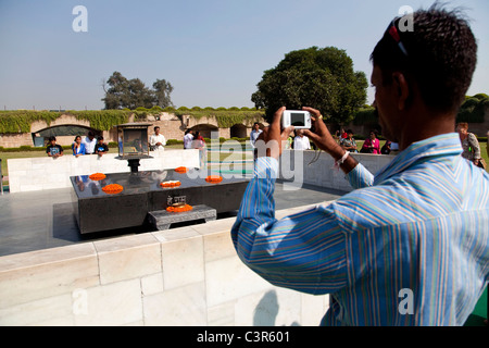 Mann unter Bild mit Kamera an Gandhis Grabstätte, Delhi, Indien Stockfoto