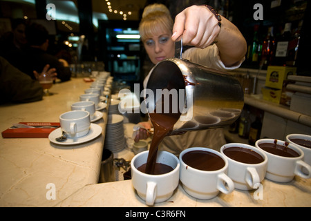 06:34: eine Kellnerin serviert heiße Schokolade für traditionelles spanisches Frühstück "chocolate Con Churros" bei San Gines, in Madrid. Stockfoto
