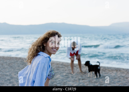 paar am Strand spielen mit Hund Stockfoto