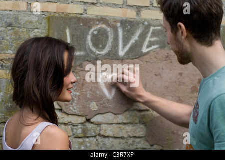 Freund schreiben Liebe an einer Wand Stockfoto