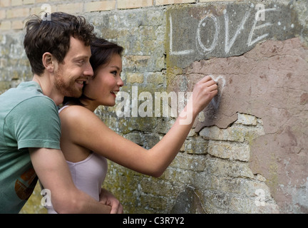 Freundin schreiben Liebe an einer Wand Stockfoto