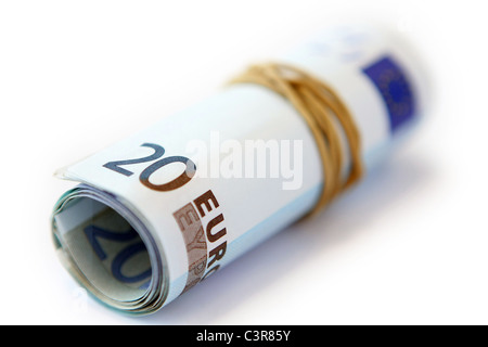 Euro-Banknoten in einem Gummiband vor einem weißen Hintergrund aufgerollt Stockfoto