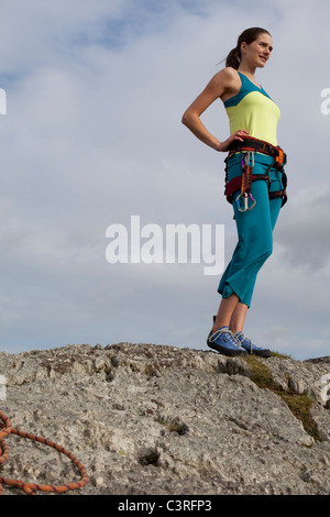 Frau in Kletterausrüstung auf Felsen Stockfoto
