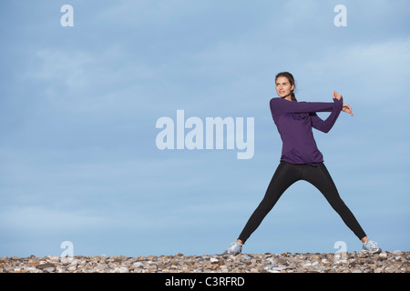 Frau am Strand dehnen Stockfoto