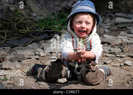 Ein kleiner Junge spielt mit Spielzeug im Schlamm. Stockfoto