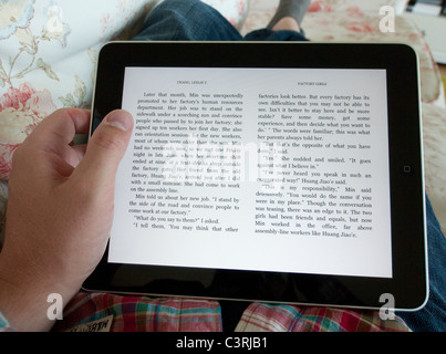 Mann liest digitalen e-Book mit Amazon Kindle app auf einem iPad Touchscreen-Tablettcomputer Stockfoto