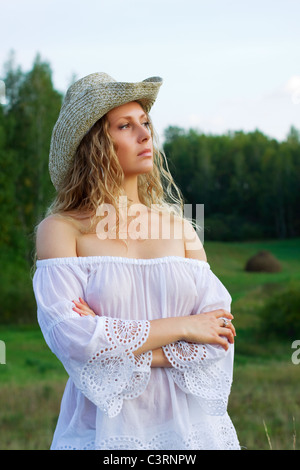 Schöne junge Frau zu Fuß in ein Feld. Stockfoto