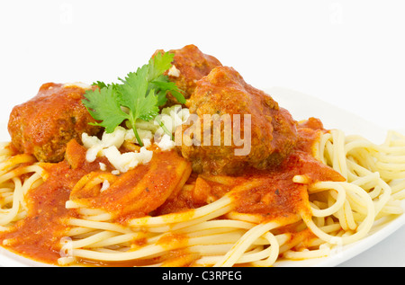 Nahaufnahme von Frikadellen in roter marinara Sauce über Spaghetti und garniert mit Koriander Zweige und Bits von Romano Käse. Stockfoto