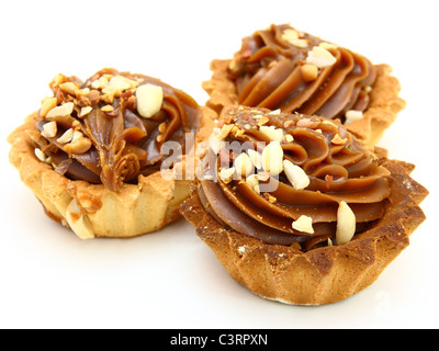 Pie einen Korb mit kondensierter Milch Schokolade und Nüssen auf weißem Hintergrund Stockfoto