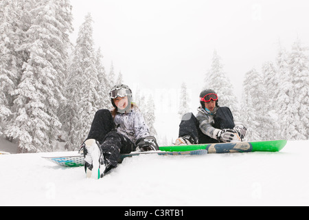 Snowboarder sitzen im Schnee Stockfoto