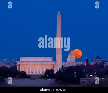 Große Vollmond steigt durch den Dunst über dem Kapitol Gebäude in Washington, D.C. mit Lincoln Memorial und das Washington Monument ausgerichtet Stockfoto