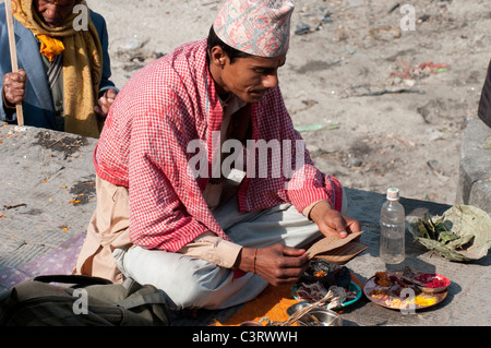 Priester liest Schriften bei den Hindu-Einäscherungsghats von Pashupatinath auf dem heiligen Bagmati, Kathmandu, Nepal Stockfoto