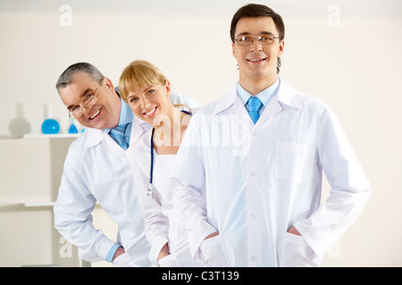Porträt von freundlichen Therapeuten in einer Schlange stehen und Blick in die Kamera mit glücklich Kliniker vor Stockfoto