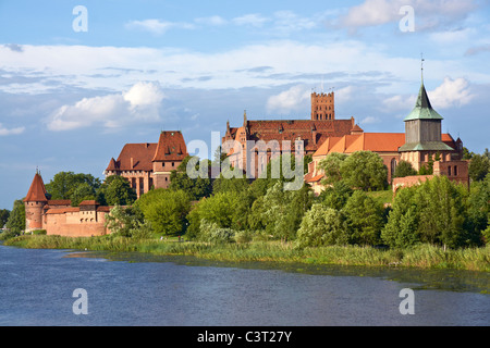 Schloss Marienburg. Blick vom gegenüberliegenden Flussufer. Der größte Backsteinbau. Stockfoto