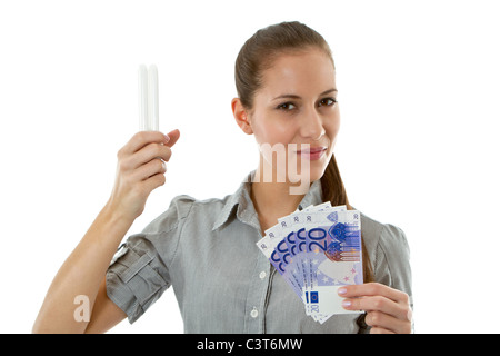 Frau mit Energiespar-Lampe und Euro Rechnungen Stockfoto