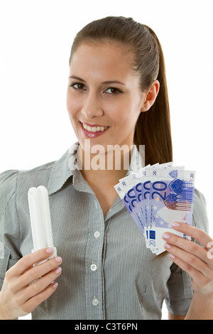 Frau mit Energiespar-Lampe und Euro Rechnungen Stockfoto