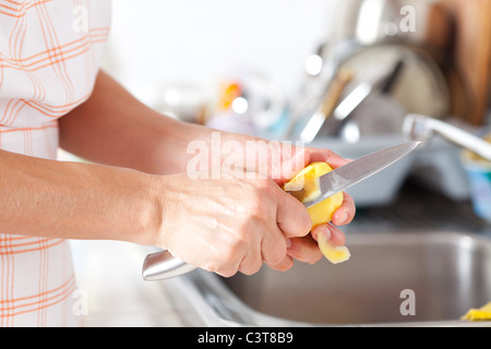 Weibes Hände Closeup, Kartoffelschälen in der Küche Stockfoto