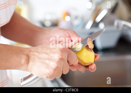 Weibes Hände Closeup, Kartoffelschälen in der Küche Stockfoto