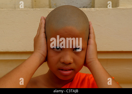 HEAR NO EVIL, junge Novizin machen die drei weisen Affen, die sprichwörtliche Prinzip, Wat Santithammaram, Bangkok, thailand Stockfoto