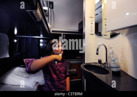 2010. 10 Jahre alten Mädchen Bürsten ihre Zähne vor dem Bett in ihrem Amtrak-Schlafwagen für die Reise von Chicago nach Washington, DC. Stockfoto